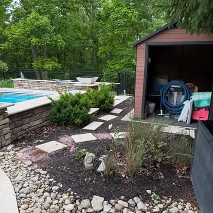 Lush backyard with a pool, shed, walking path, and garden landscape in a wooded area.